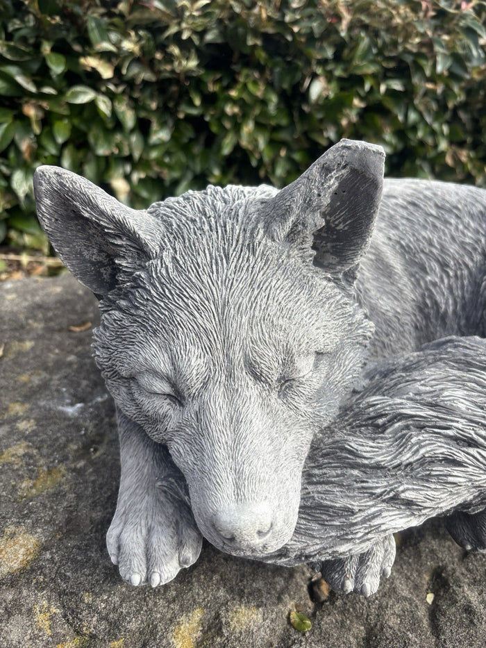 handcrafted grey concrete fox statue in a sleeping pose, detailed fur texture for outdoors.
