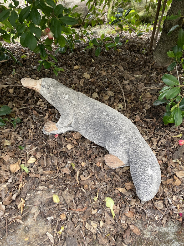 22nice4me Garden Statues hand-painted concrete platypus sculpture standing on dry leaves in a garden setting