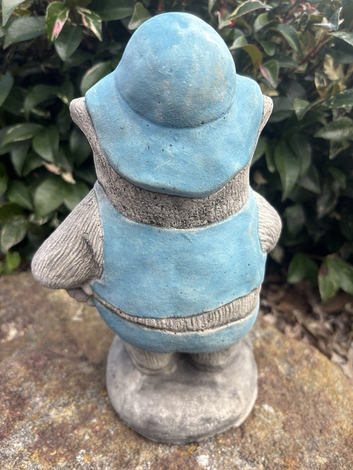 Back view of 22nice4me Garden Statues concrete wombat wearing a blue hat and vest in a garden setting