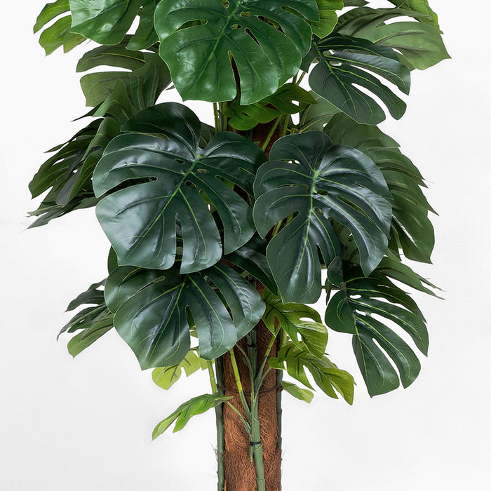 Artificial monstera plant with large green leaves on a white background