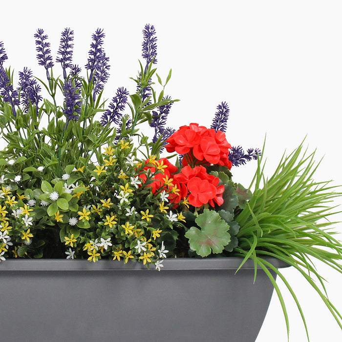 Gray planter with a variety of colorful flowers on a white background