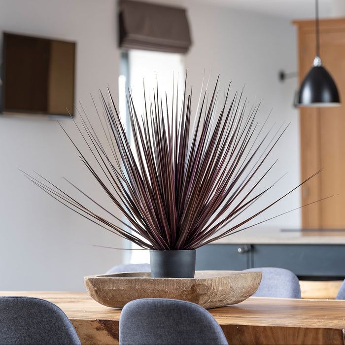 Decorative plant in a pot on a wooden table with a modern interior background