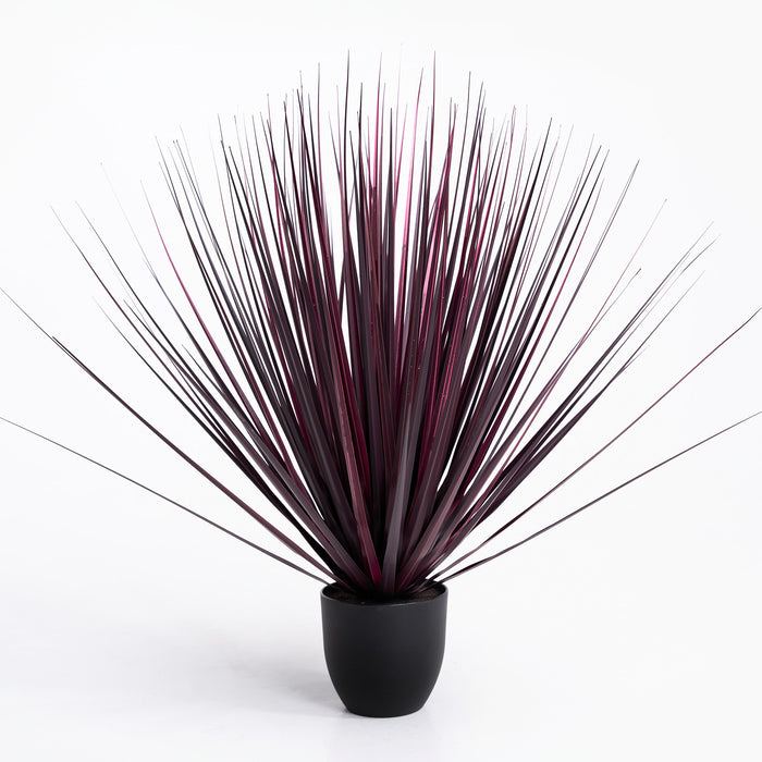 Artificial plant with long, thin leaves in a black pot on a white background