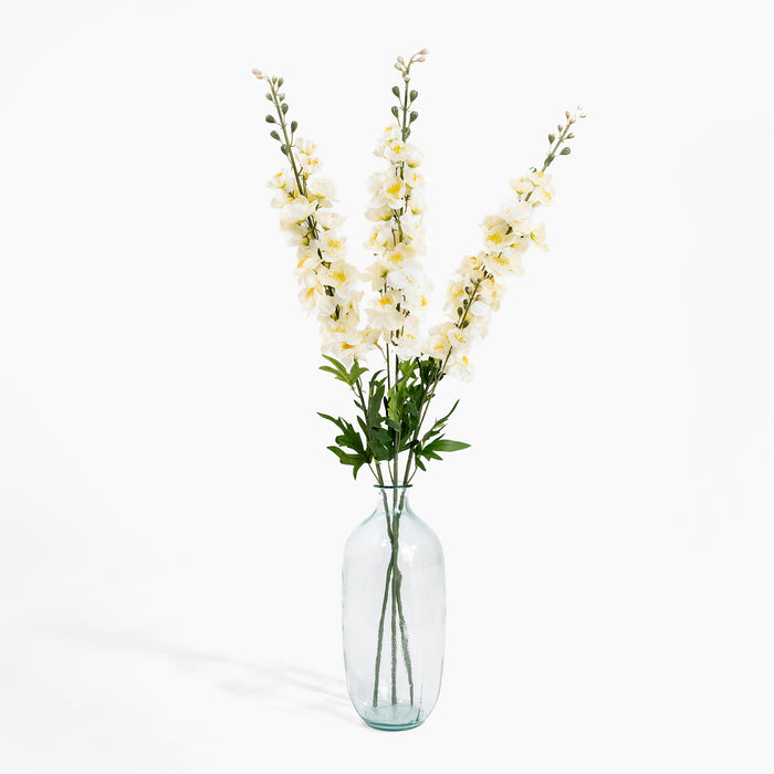 Clear glass vase with yellow flowers on a white background