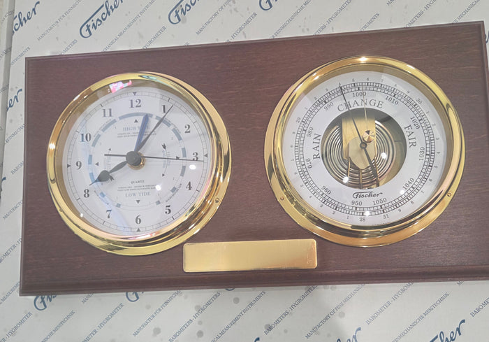 Dual dial tide clock and barometer with gold trim on a wooden base, nautical weather instrument