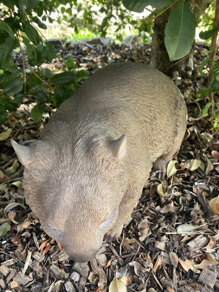 22nice4me Garden Statues hand-painted resin wombat figurine standing in a garden setting with mulch and foliage