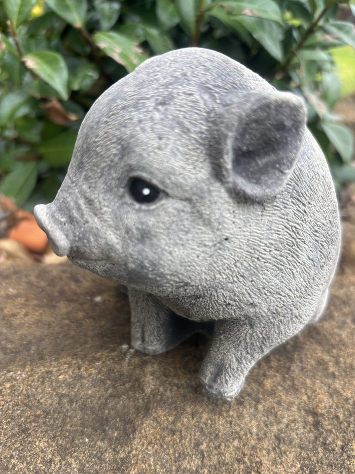 22nice4me Garden Statues hand-painted concrete piglet ornament sitting on a stone surface in a garden setting