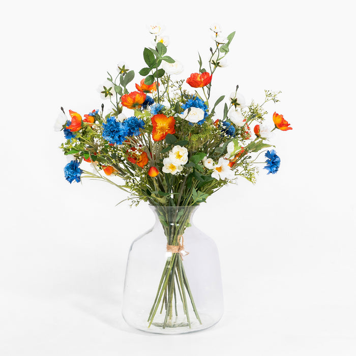 Bouquet of colorful flowers in a clear vase on a white background