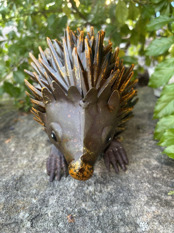 22nice4me Garden Statues handcrafted metal echidna ornament in brown with yellow highlights on a stone surface