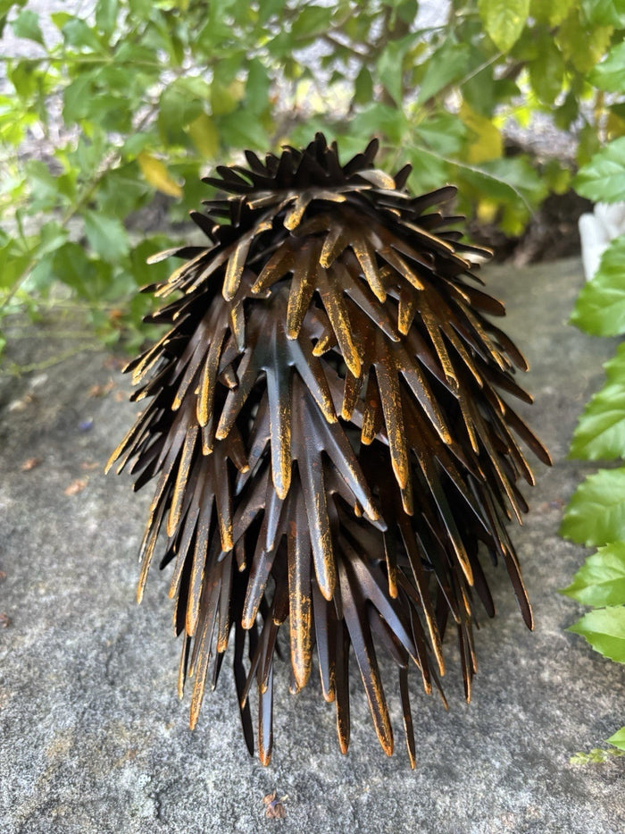 22nice4me Garden Statues handcrafted metal echidna ornament in brown with yellow highlights on a stone surface