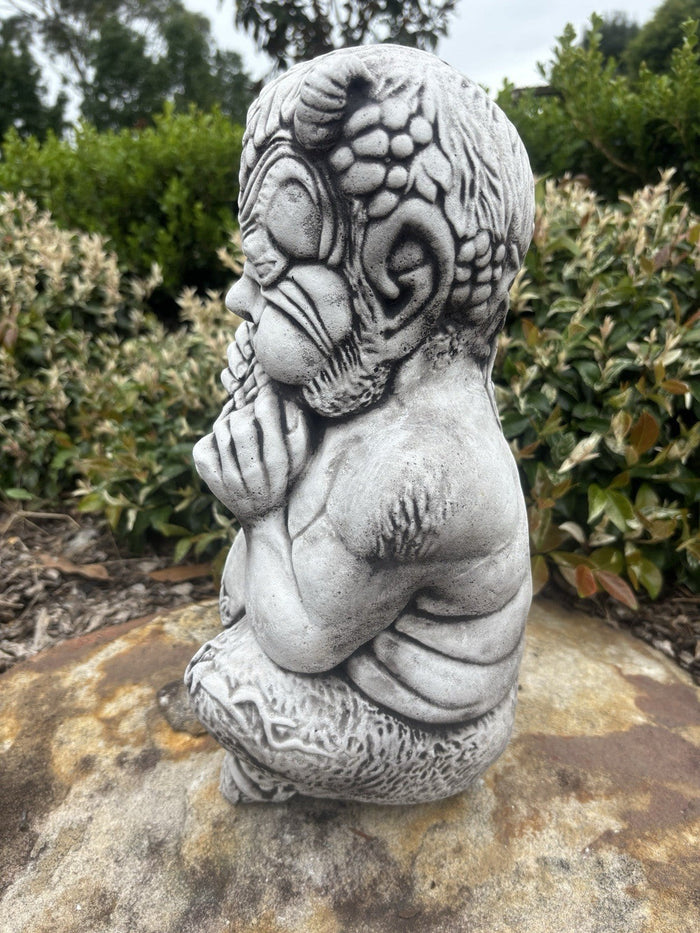22nice4me Garden Statues concrete Pan statue with an antique finish, shown in profile playing pan pipes in a garden.