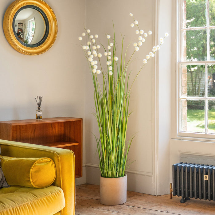 Living room with yellow sofa, plant, and window view