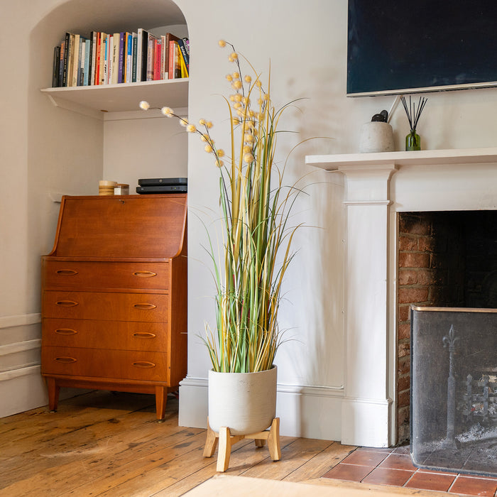 Nestled corner of a room with wooden cabinet, potted plant, and fireplace.