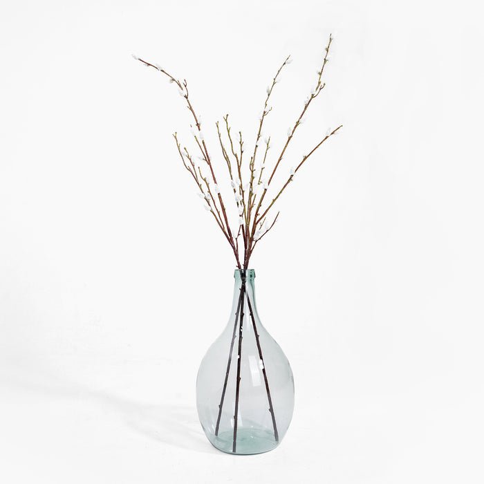 Clear glass vase with dried branches on a white background