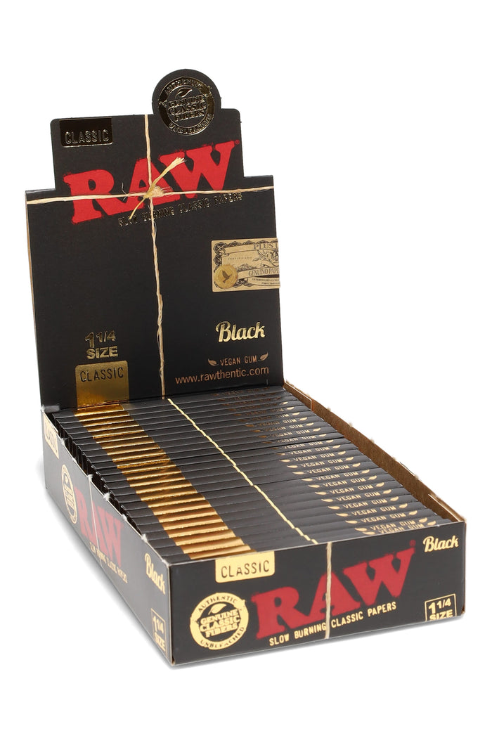 RAW Black 1¼ rolling papers 24-count display box in matte black and gold, featuring slim unbleached sheets and vegan acacia gum branding.