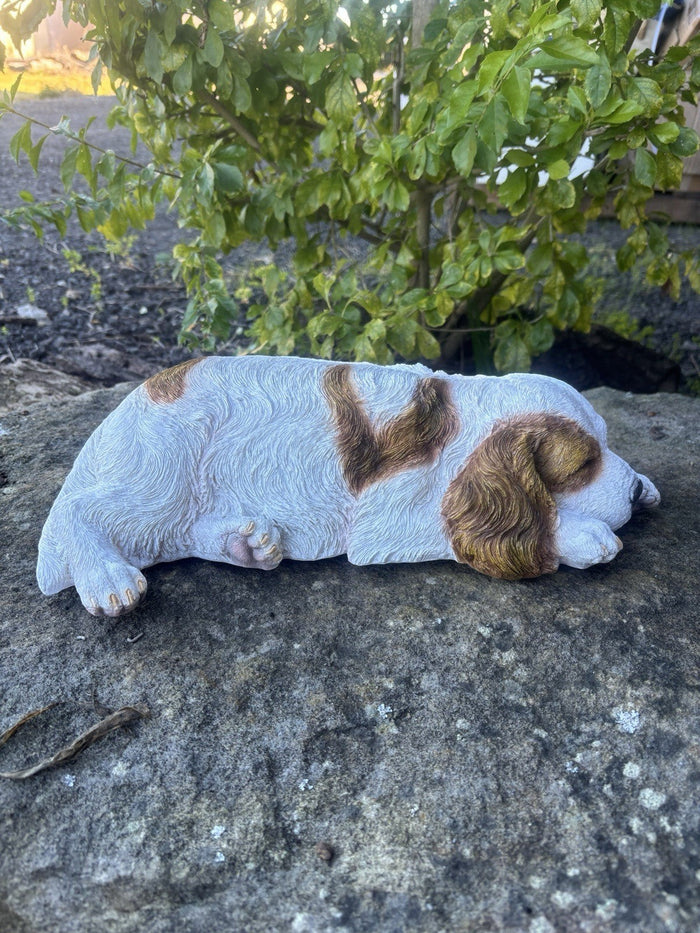 resin Cavalier King Charles Spaniel ornament in a realistic laying pose on a stone surface