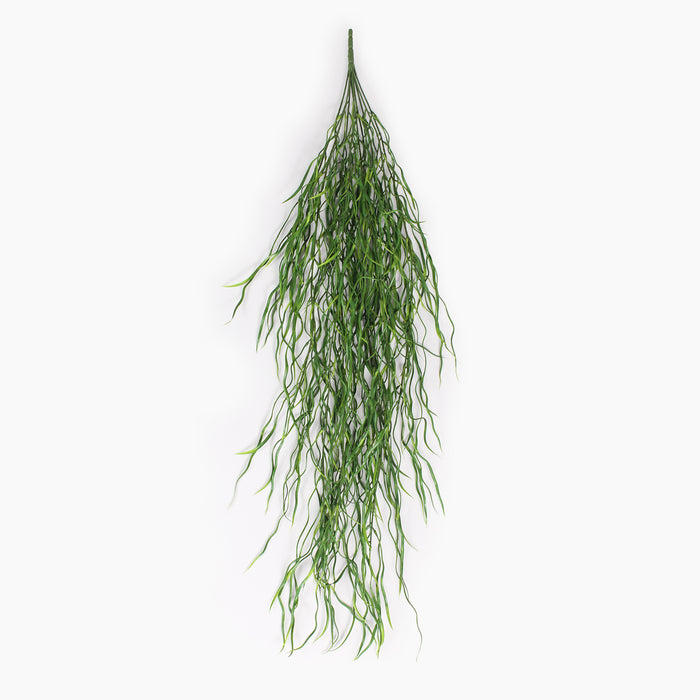 A hanging green artificial plant stem with long, wispy, needle-like leaves, shown against a plain white background.