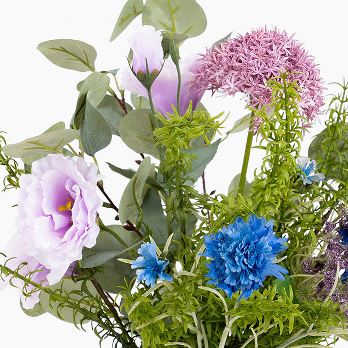 Assorted artificial flowers including pink, blue, and green on a white background