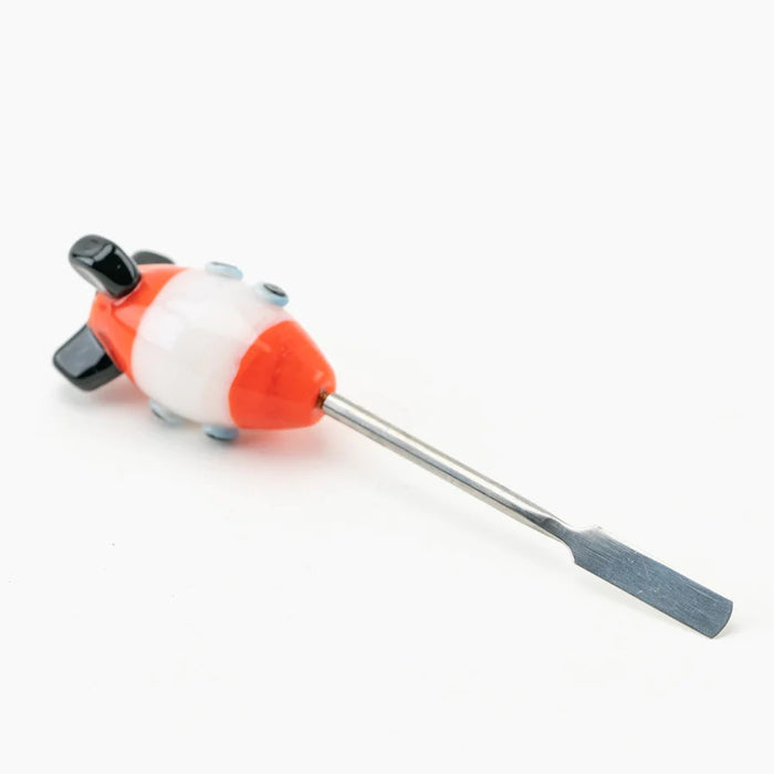 Angled shot of space-cruiser glass dabber lying down, focusing on stainless blade tip, oval rocket hull, and thruster fins on white surface.