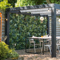 Outdoor patio area with a pergola, table, and chairs in a garden setting.