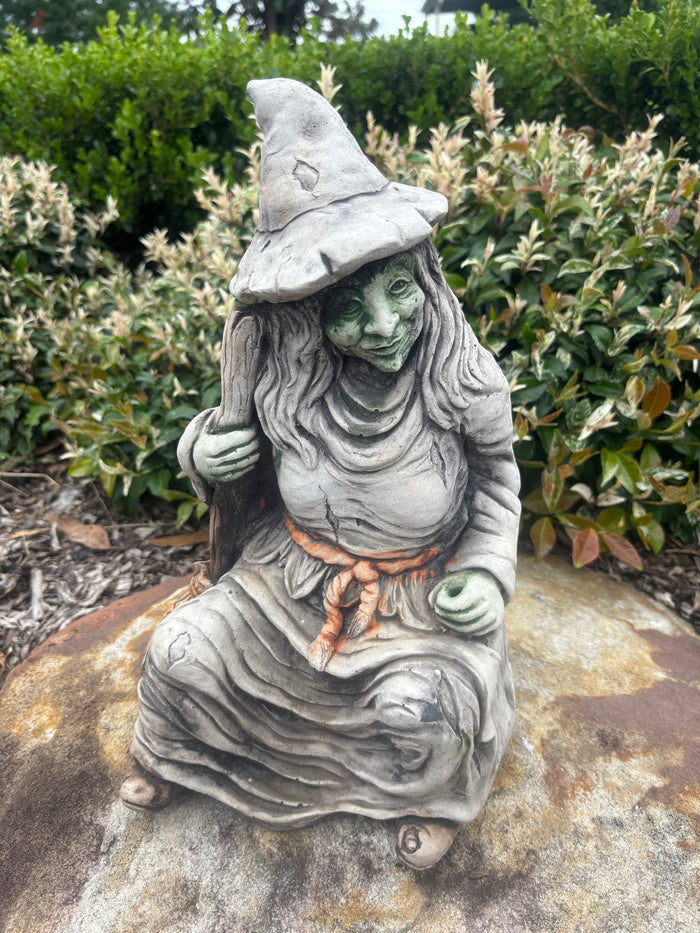 22nice4me Garden Statues hand-painted concrete witch statue with broomstick sitting on a rock in a garden setting